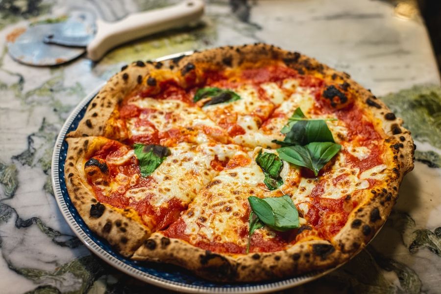 Pizza margherita con basilico fresco appena sfornata